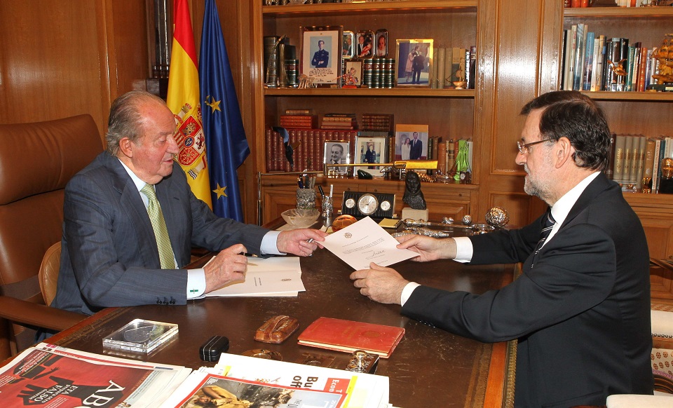 El rey Juan Carlos I entrega a Rajoy el documento de abdicación.
