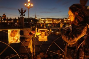 Una mujer se emociona junto a imágenes de fallecidos en un accidente aéreo en Egipto colocadas en una valla en plaza de (palacio) Dvortsovaya en San Petersburgo, Rusia, de donde eran la mayoría de las víctimas, el 3 de noviembre de 2015. (Foto AP/Dmitry Lovetsky)