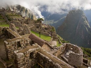 Wide shot of Machu PIcchu, including the Temple of the sun, and the surrounding mountains.